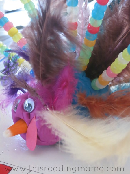 adding feathers to playdough to make a turkey