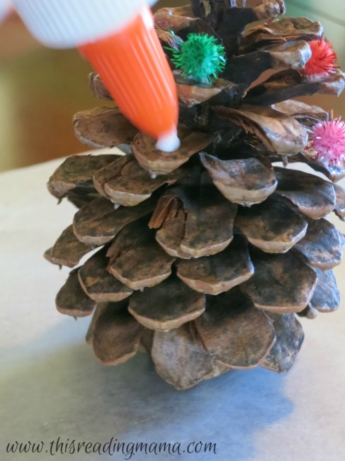 squeezing glue onto pine cones